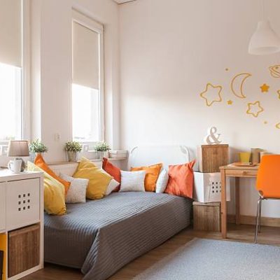 Yellow and orange accessories in modern teen room
